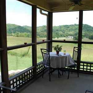 Screened-in porch wraps around three sides of the bed and breakfast.